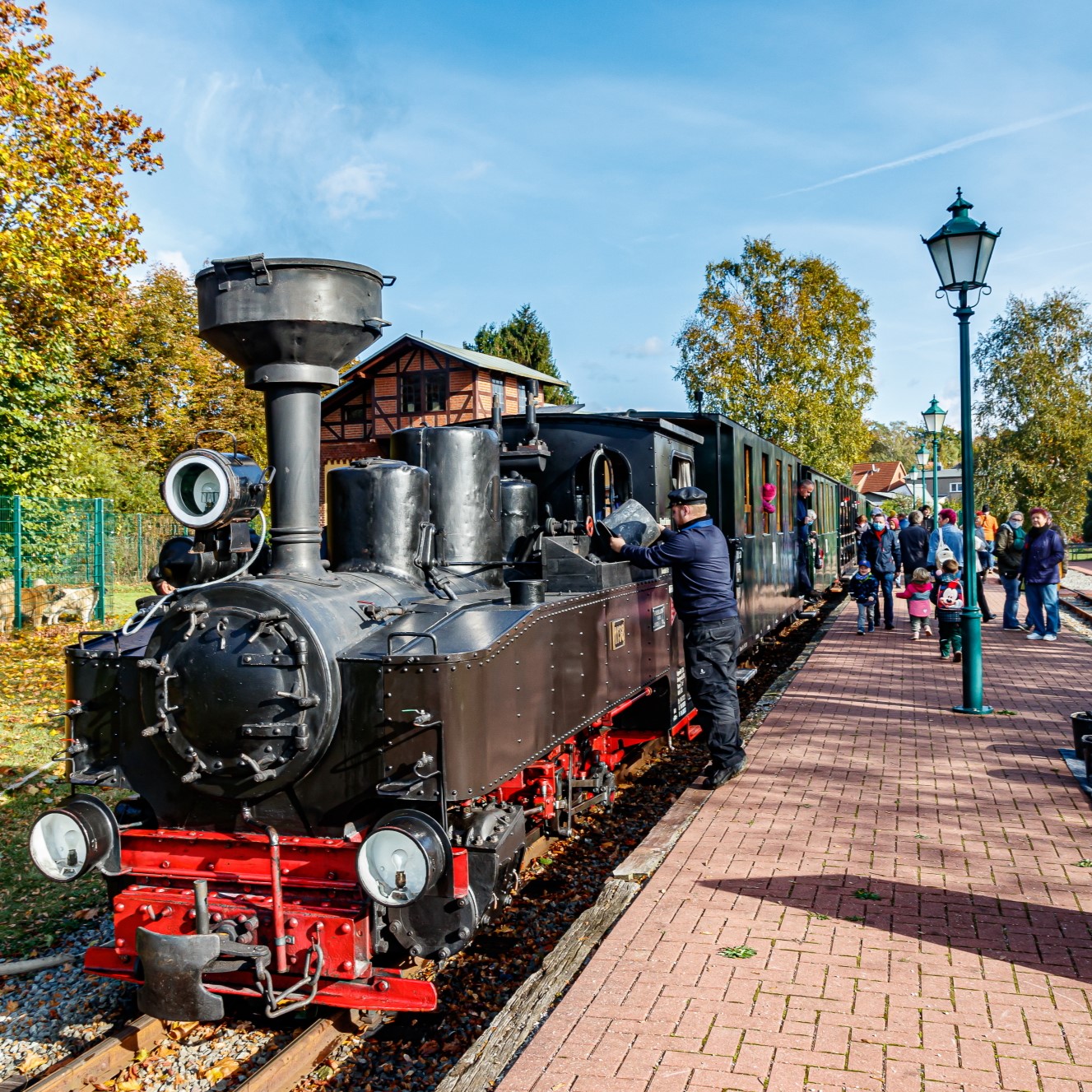 Historic small train at the station with engine driver.